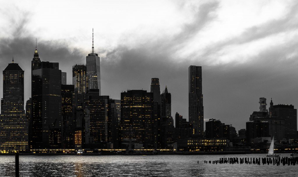 vue sur la skyline et sur des building iconiques comme la One World sous un ciel tres nuageux -Retrouvez nos conseils sur le blog de New York Off Road, visites guidées en français de la Grosse Pomme