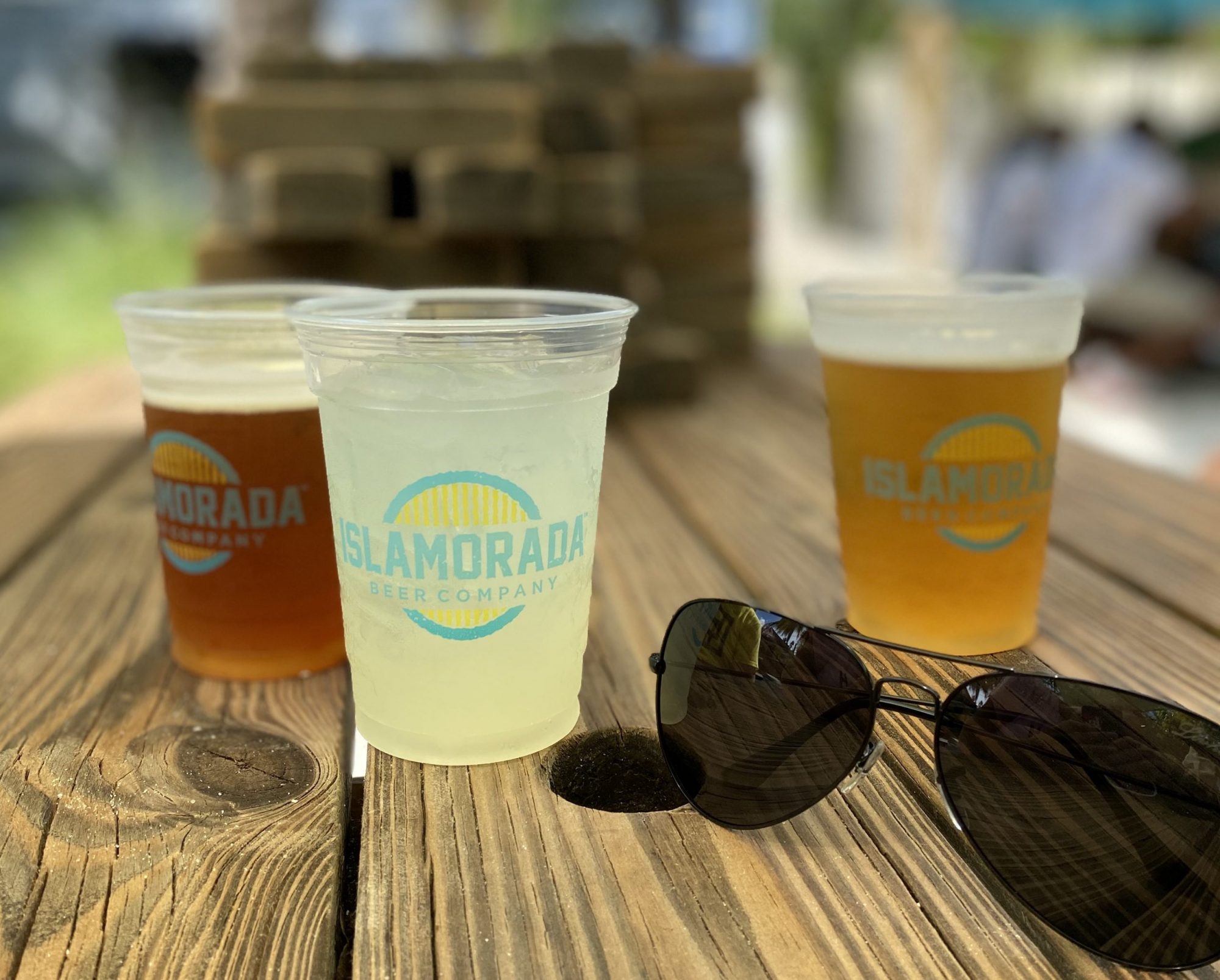 verres de bières fraiches sur une table en bois dans le patio de la Islamorada Brewery and Distillery. Une adresse des Keys recommandée par Miami Off Road